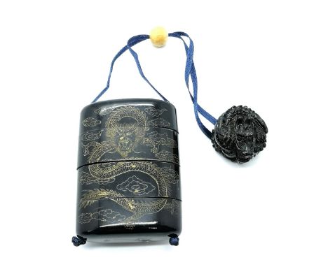 A carved and signed Japanese four section Inro with gilt dragon design and carved fruitwood dragon netsuke