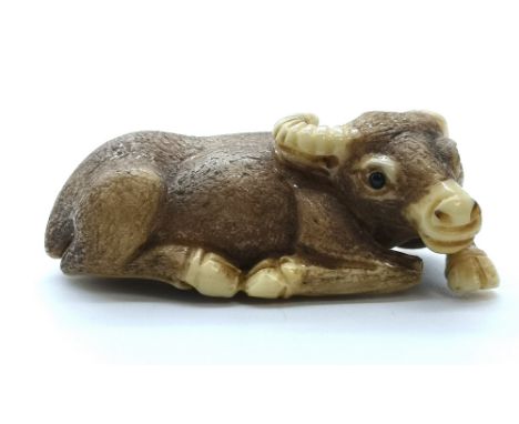 A signed carved ivory Japanese netsuke of a lying Water Buffalo