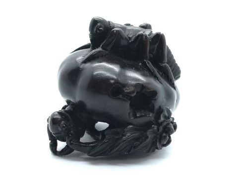 A carved wooden Japanese netsuke study of a sitting locust