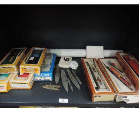 A shelf of Bachmann, Tyco and similar 00 gauge plastic rolling stock, a tube of blue paper plans for RMS Queen Mary ship and 