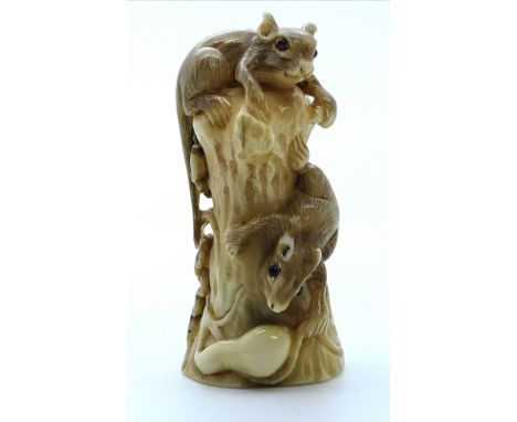 A signed and carved ivory Japanese netsuke of two squirrels on a tree stump