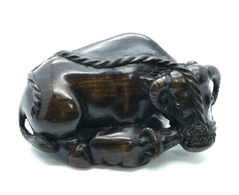 A signed carved wooden Japanese netsuke of a water buffalo and calf