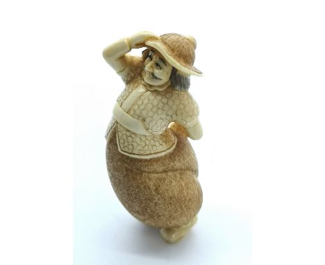 A signed carved ivory Japanese netsuke of a foreign visitor hiding his sword behind his back