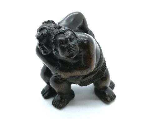 A carved and signed fruitwood Japanes netsuke a study of two sumo wrestlers