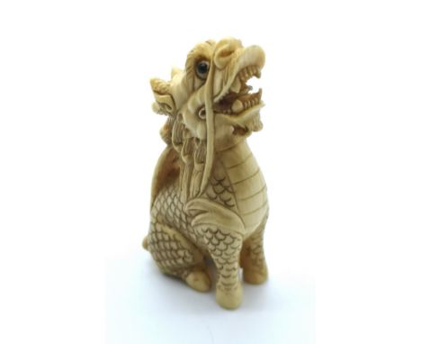 A signed carved ivory Japanese netsuke of a sitting dragon