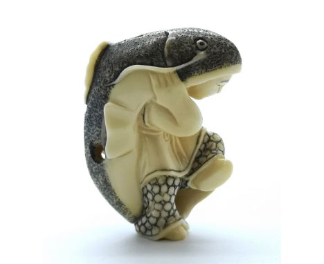 A carved ivory Japanese netsuke of a man carrying a large cat fish