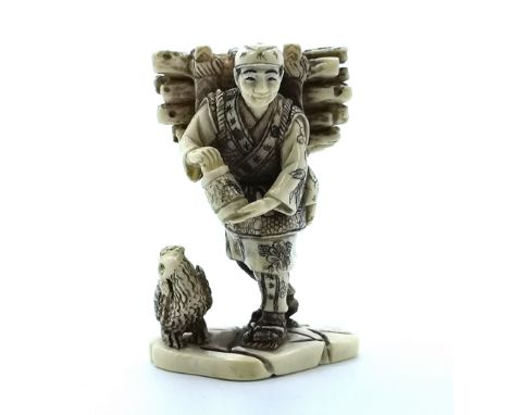 A signed and carved ivory Japanese netsuke of a woodcutter feeding a bird 