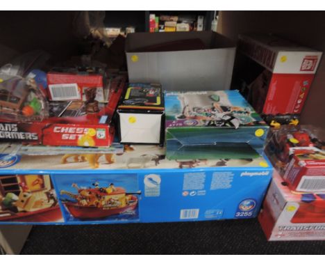 A shelf of modern toys including Playmobil set 3255, Transformer Chess Set and modals, most items boxed