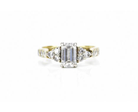 An 18ct yellow gold and diamond engagement ring, with central emerald cut diamond approx. 1ct, flanked either side by old cut