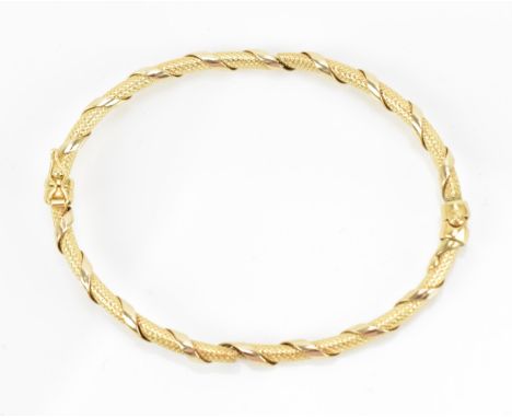 An 18ct yellow gold bangle bracelet, with textured tube wrapped in a ribbon style, a/f, inner width 6.5 cm, weight 6.1 grams 