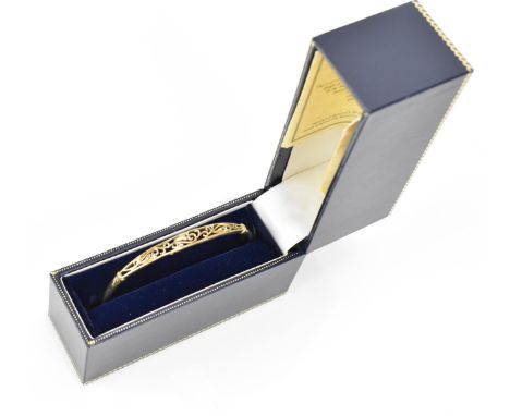 A 9ct yellow gold and diamond bangle bracelet, with pierced scroll design set with six diamond accents, 6 grams 