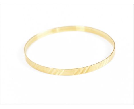 An 18ct yellow gold bangle bracelet, with textured design, 7 cm diameter, stamped 750, weight 11.7 grams 
