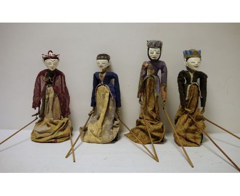 Set of four Eastern painted wood puppet dolls, each on a stand and with arms operated by wooden rods, all dressed in printed 