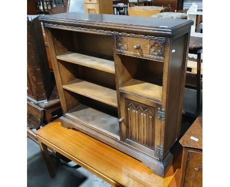 20th century oak bookcase with three shelves, one drawer over shelf and cupboard, with moulded top, on bracket supports, 94cm