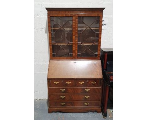 20th century mahogany bureau bookcase with moulded cornice above two astragal glazed doors enclosing shelves, the base of two