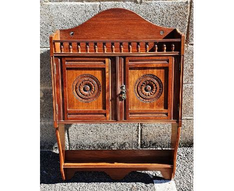 James Shoolbred of London wall-hanging cabinet, the arched back above spindle turned gallery, two cupboard doors with carved 