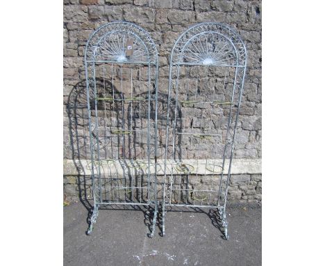 A pair of freestanding light steel flower pot stands of arched form with lattice scroll and further detail, each framework su