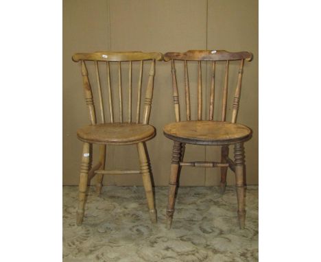 A harlequin set of four stripped elm and beechwood Swedish stick back kitchen chairs with circular seats raised on turned sup