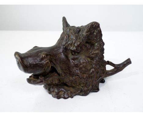 A good heavy bronze inkwell in the form of a boar's head, with hinged cover, to the rear a pen rest, 11cm high 
