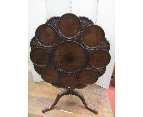 A Georgian mahogany supper table of eight settings with further carved detail raised on a turned pillar and carved tripod bas