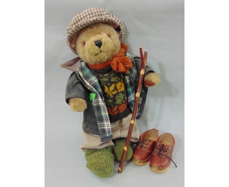 A Lakeland bear dressed in country wear including a waxed jacket, flat cap, wooden walking clogs and wooden walking stick (1)