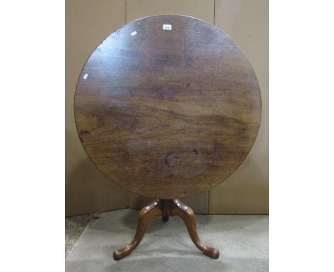 A Georgian mahogany snap top occasional table of circular form raised on a turned vase shaped fluted pillar and swept tripod,