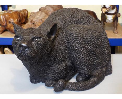 A larger than life-size bronze figure of a glowering cat, 26cm in height