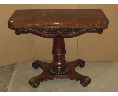 A William IV rosewood veneered fold over top card table of rectangular form with rounded front corners and scrolled frieze ra