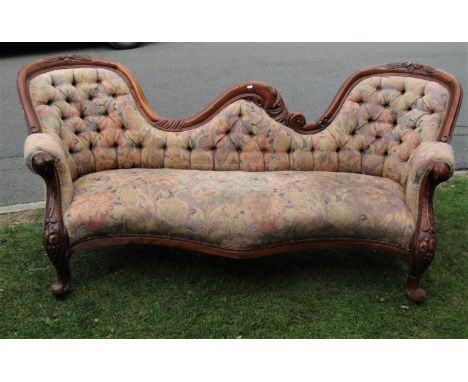 A Victorian style twin spoon back sofa with serpentine shaped floral patterned upholstered seat within a showwood frame raise