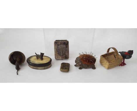 A bronze pin cushion in the form of a hedgehog, a 19th century horn snuff box and cover of oval form surmounted by a dog, a V