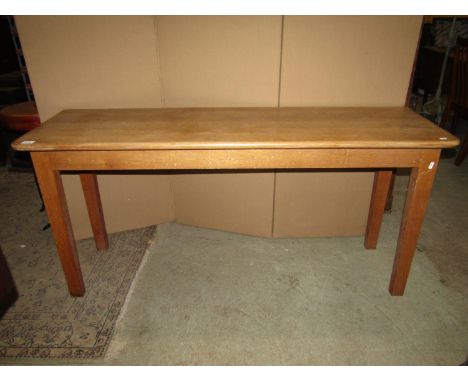 A good quality narrow light oak side table of rectangular form with moulded outline and rounded front corners raised on four 