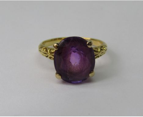 Amethyst dress ring in four prong setting, in unmarked yellow metal with scrolled shoulders, size K, 3.3g 