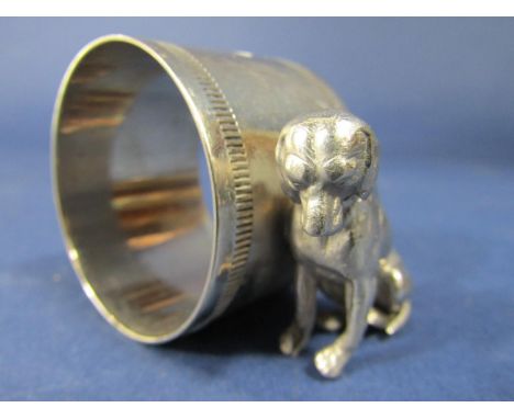 Novelty silver plated napkin ring, the circular ring flanked by a seated hound, 6 cm long 