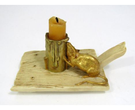 A Worcester chamber stick in the form of a cheese board with simulated wood grain finish surmounted by a gilded rat nibbling 