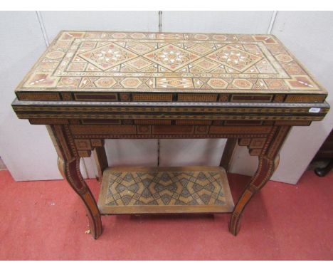 A Moroccan marquetry games table of rectangular form raised on four shaped supports with under gallery, comprehensively inlai