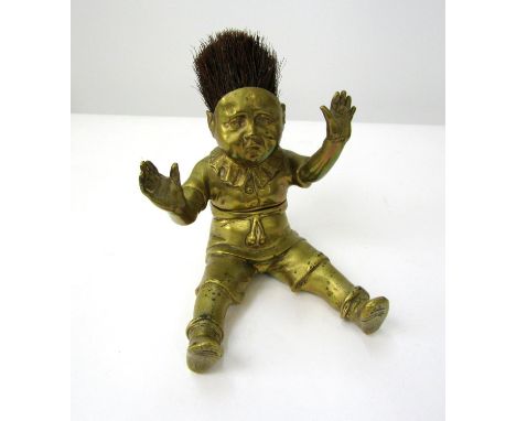 Good quality Victorian brass inkwell/nib wipe in the form of a seated boy, hands aloft, legs apart with hinged body. 14cm 