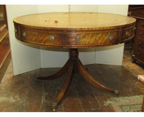 A Georgian style drum table, the circular top enclosing four real and four dummy drawers, brass ring handles with leather top