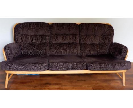 An Ercol light beechwood framed Windsor stickback three seat sofa with loose upholstered stylised patterned cushions 6ft long