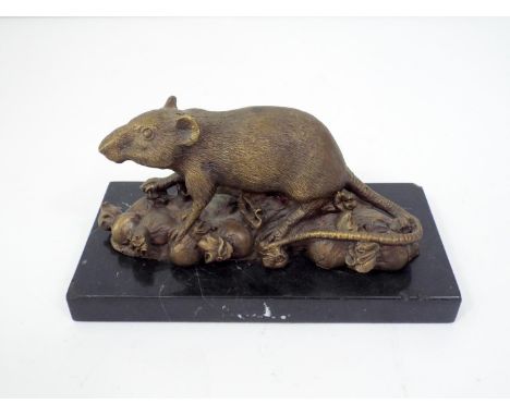 A bronze figure of a rat climbing on top of knotted bags (probably representing money) raised on a marble plinth, 20cm long 