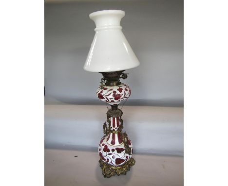 Good quality cameo glass baluster oil lamp, with applied white on cranberry, with gilt cast metal twin handles and base, 66cm