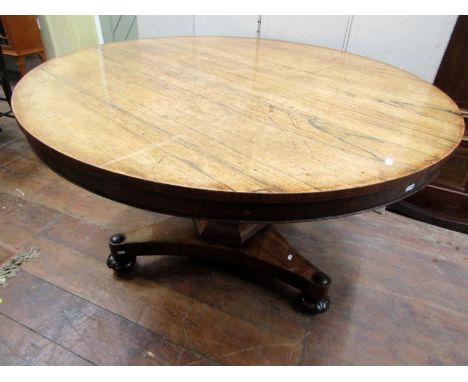 19th century rosewood tea table, the circular top raised on a tapering hexagonal pillar and tricorn base, 120cm diameter 