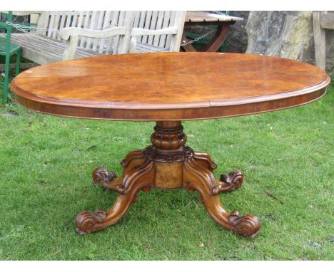 A Victorian walnut figured and burr walnut veneered oval tilt top breakfast table with moulded outline raised on a turned and