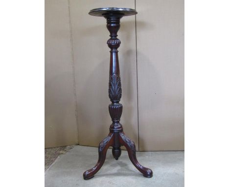 An Edwardian mahogany torchere raised on a turned and carved pillar with swept tripod 