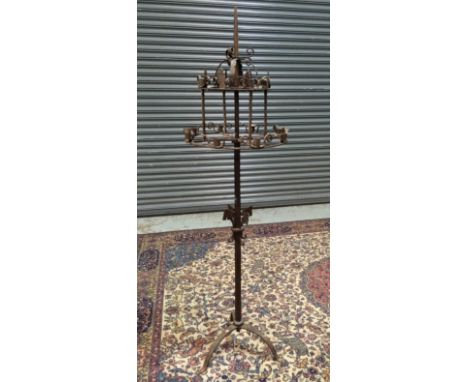 An early 20th Century wrought iron standard lamp in the ecclesiastical taste, with a twin tier of revolving candle sconces an