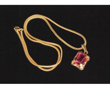 A 14ct and red stone pendant, the claw set rectangular facet cut stone within a yellow and rose gold pierced frame, suspended