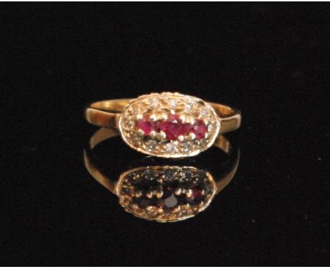A 9ct hallmarked modern ruby and diamond cluster ring, three central claw set rubies within a diamond set border, ring size I