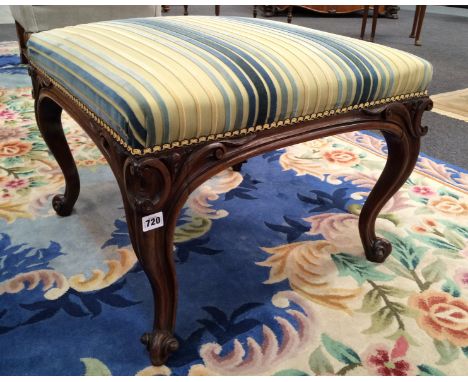 A 19th Century stool of square form, with exposed foliate and scroll carved rosewood frame, upholstered in blue and cream str