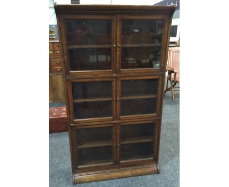 An oak three tier modular bookcase in the manner of Globe Wernicke, un-labelled, each section with double doors above the int