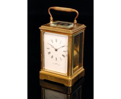 A late 19th Century French brass carriage clock with push button repeat striking on a gong, the white enamelled dial retailed