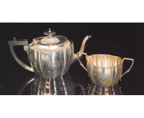 A hallmarked silver boat shaped tea pot and matching twin handled sugar basin each of plain panelled form, total weight 25oz,